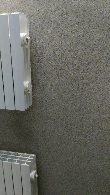 стена обработанная байрамиксом с установленными на ней радиаторами